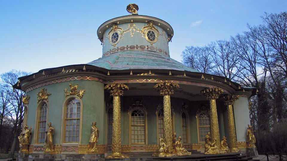 Un edificio histórico con ornamentadas decoraciones doradas y una cúpula.