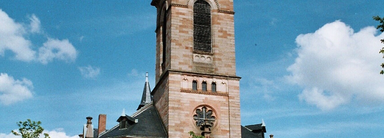 A historic church with a tall tower and a clock.