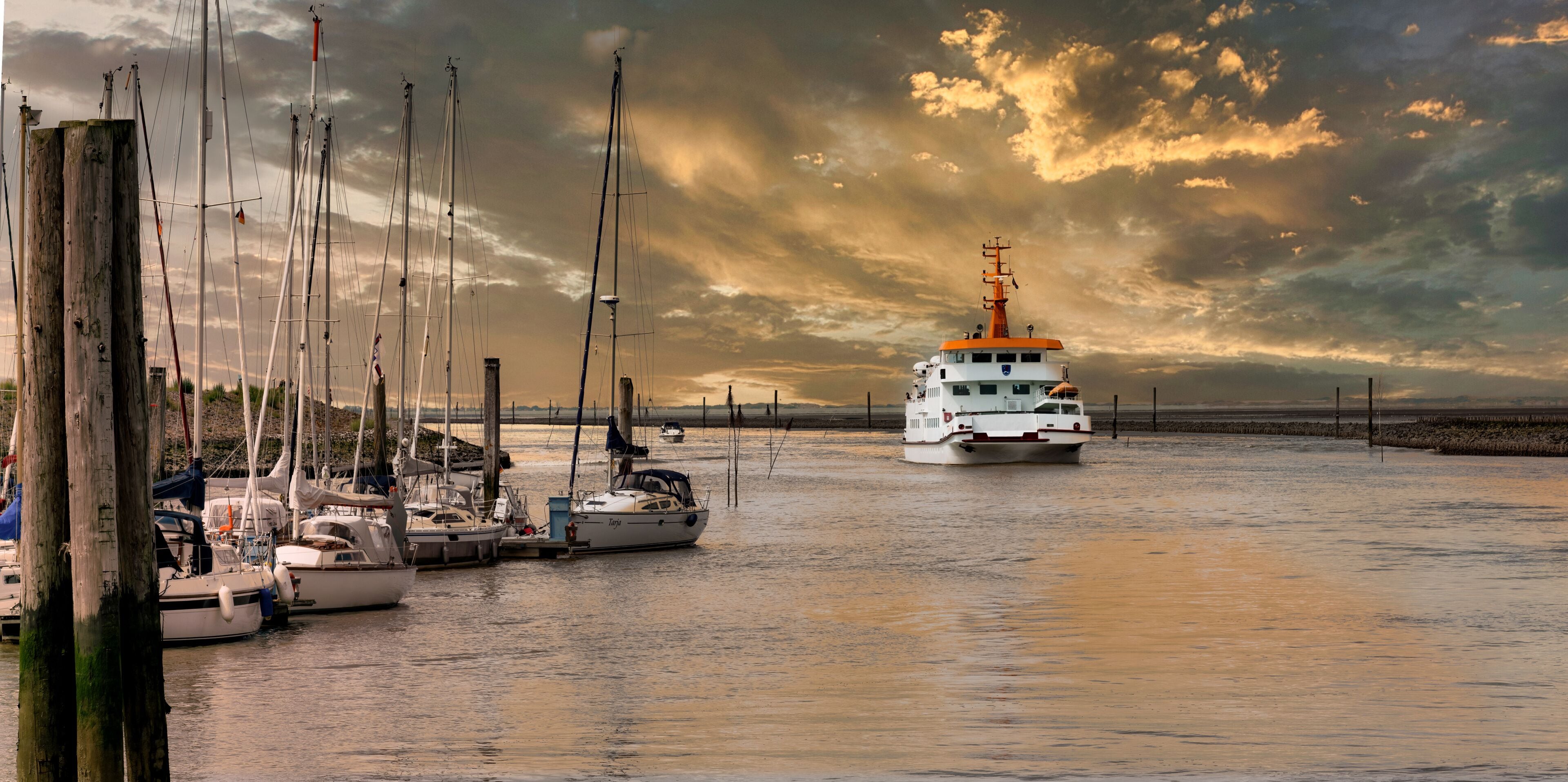 Ferry arriving in the port of Bensersiel at sunset