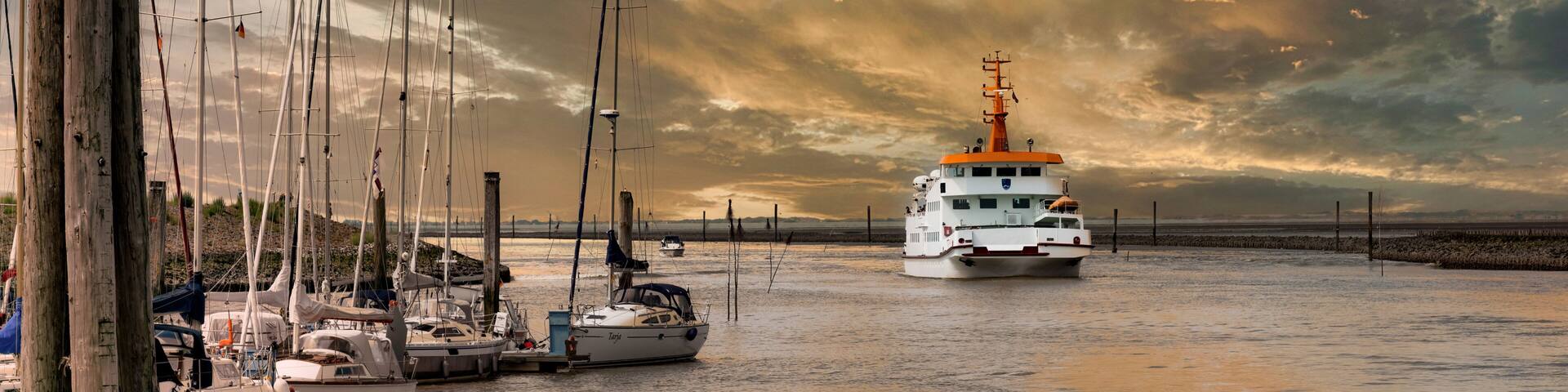 Ferry arriving in the port of Bensersiel at sunset