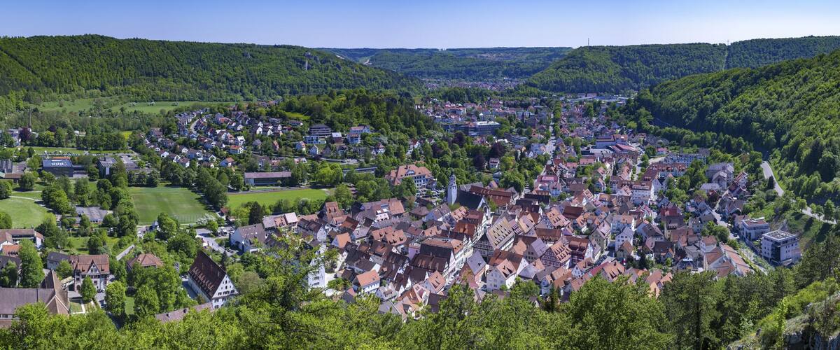 A town nestled in a valley surrounded by lush green hills.