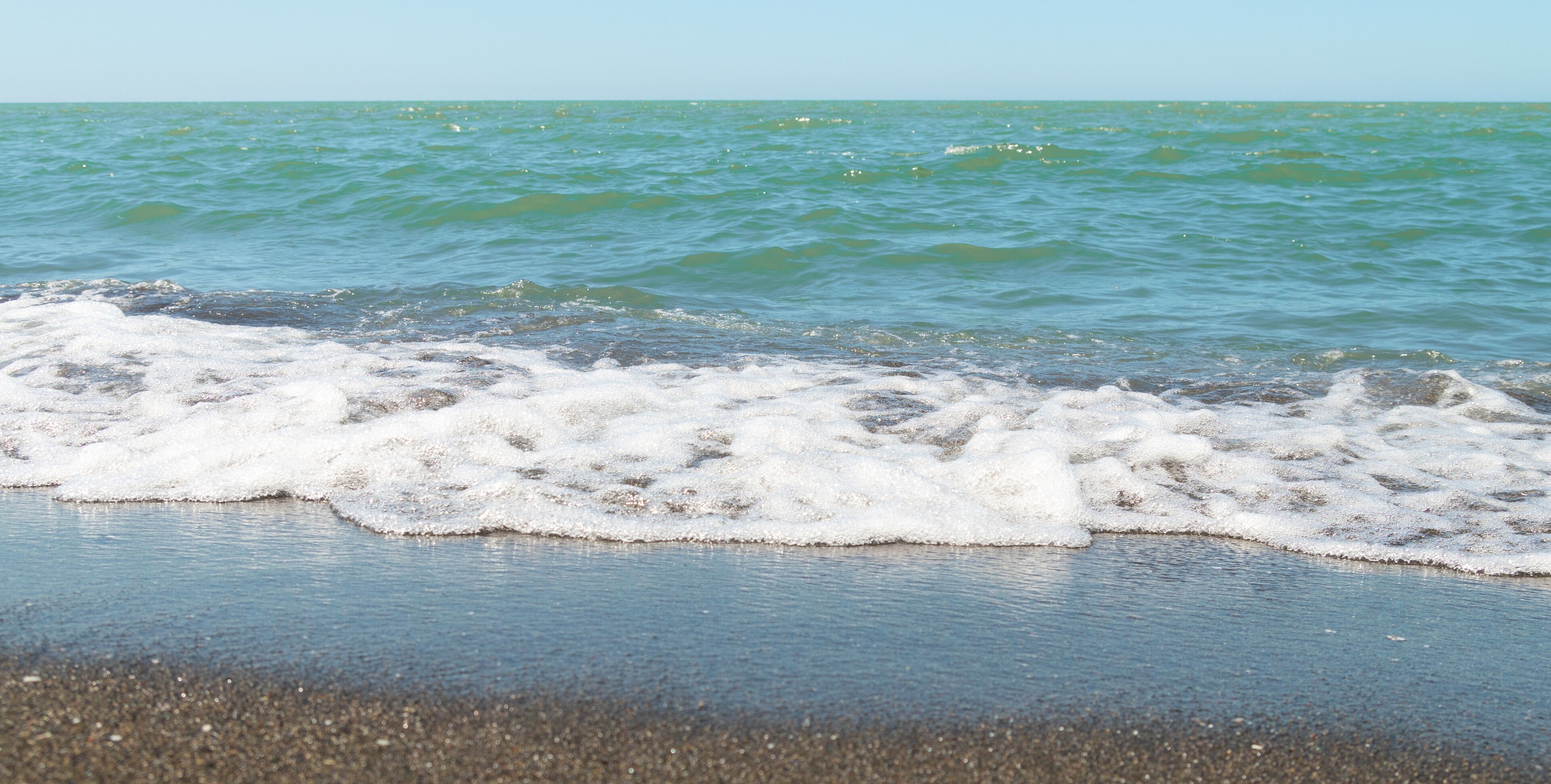 A beach with waves gently crashing onto the shore.