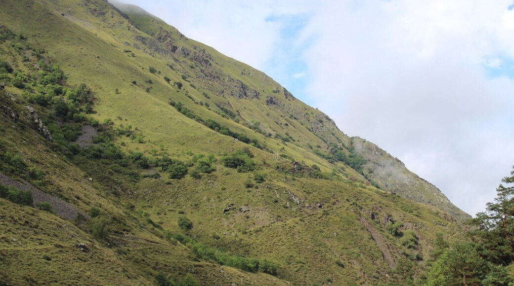 View of the border between the country of Georgia and the Russian region of Chechnya.
It is a little hard to see, but in about the exact middle of the photo, there are a couple of white poles. This is a border crossing between Georgia and Russia.
Picture taken at a place called Anatori’s Crypt in Georgia.