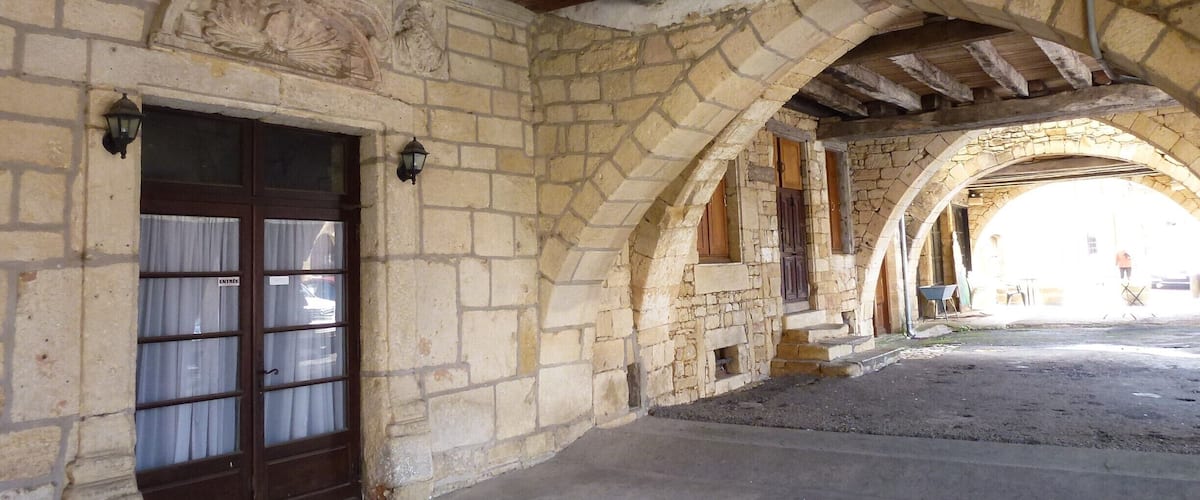 An old stone building with a wooden ceiling and a large arched doorway.