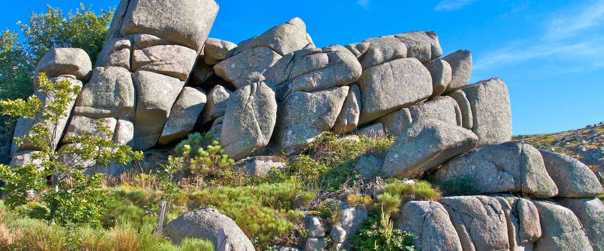 A rocky landscape with large boulders and sparse vegetation.