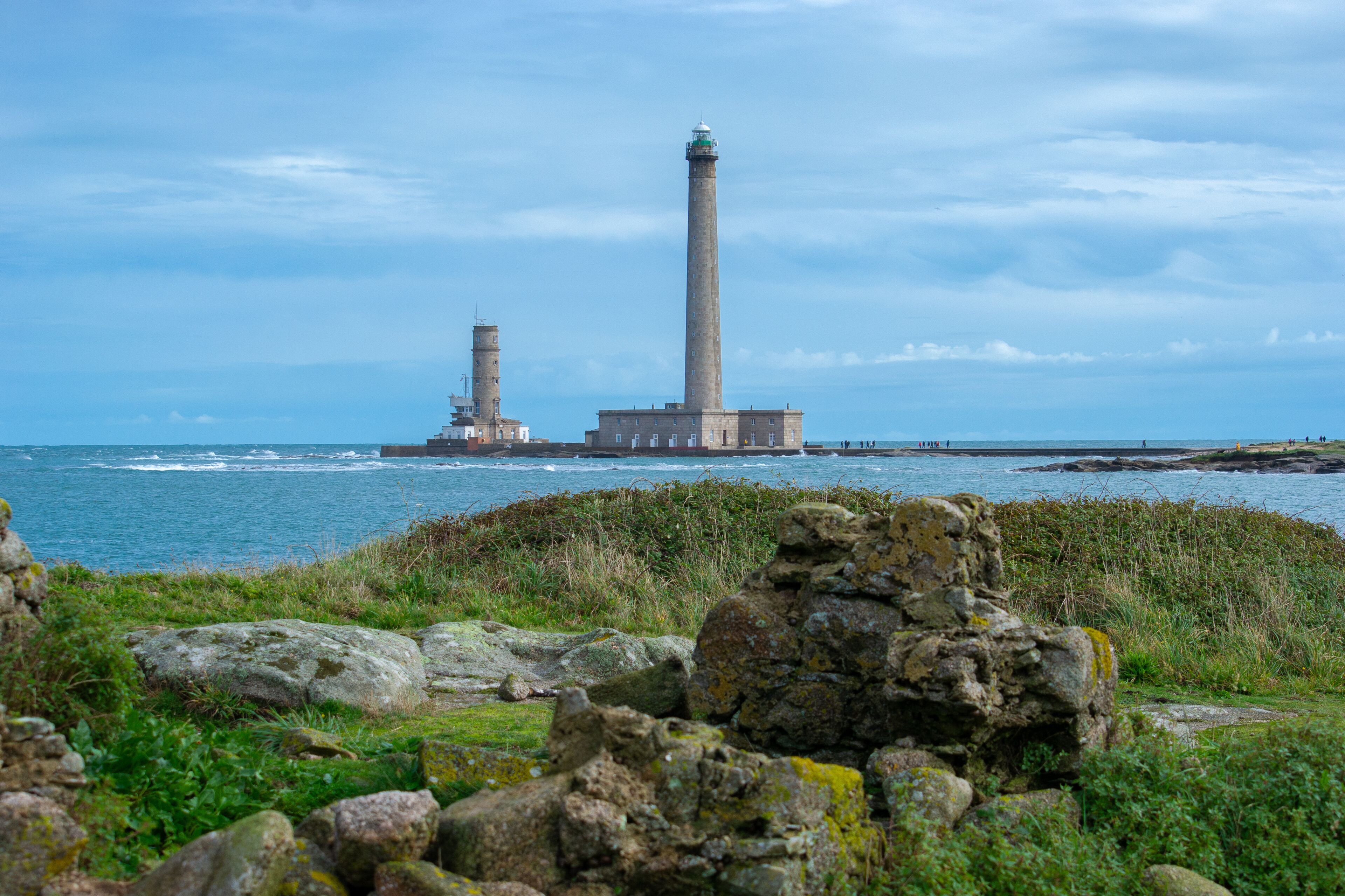 A coastal landscape with two prominent lighthouses and rocky outcrops.