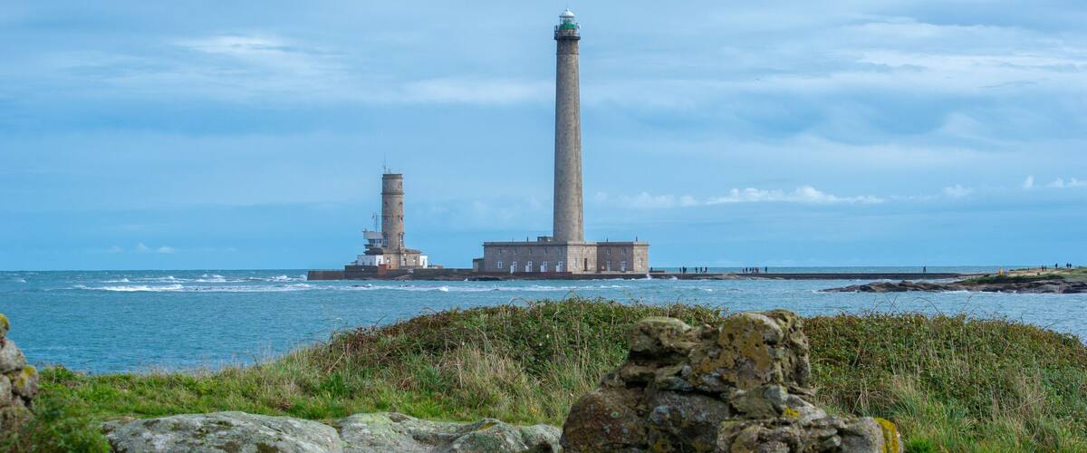 A coastal landscape with two prominent lighthouses and rocky outcrops.