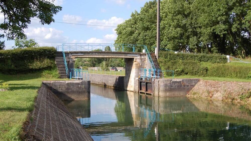 Un étroit canal surmonté d’un pont et d’un escalier.