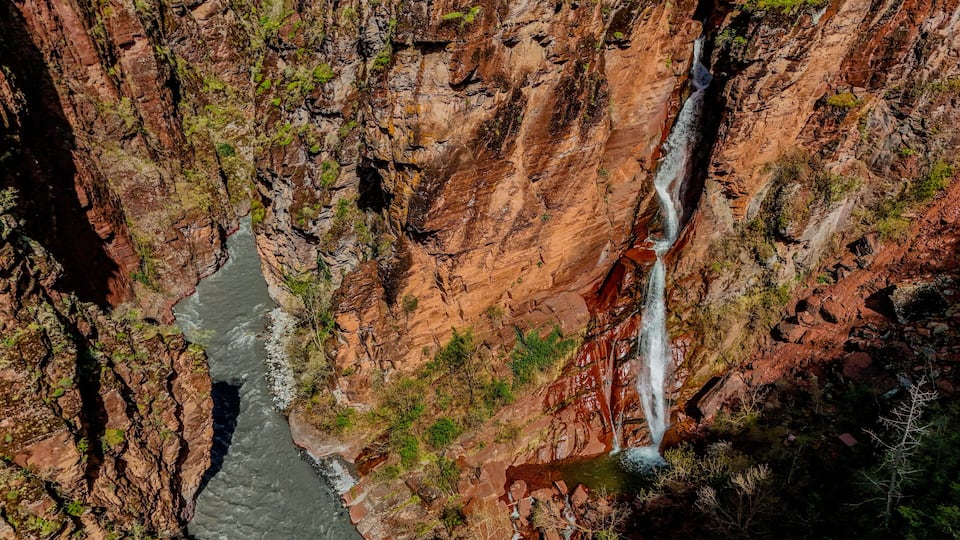 A river flowing through a canyon with a waterfall.