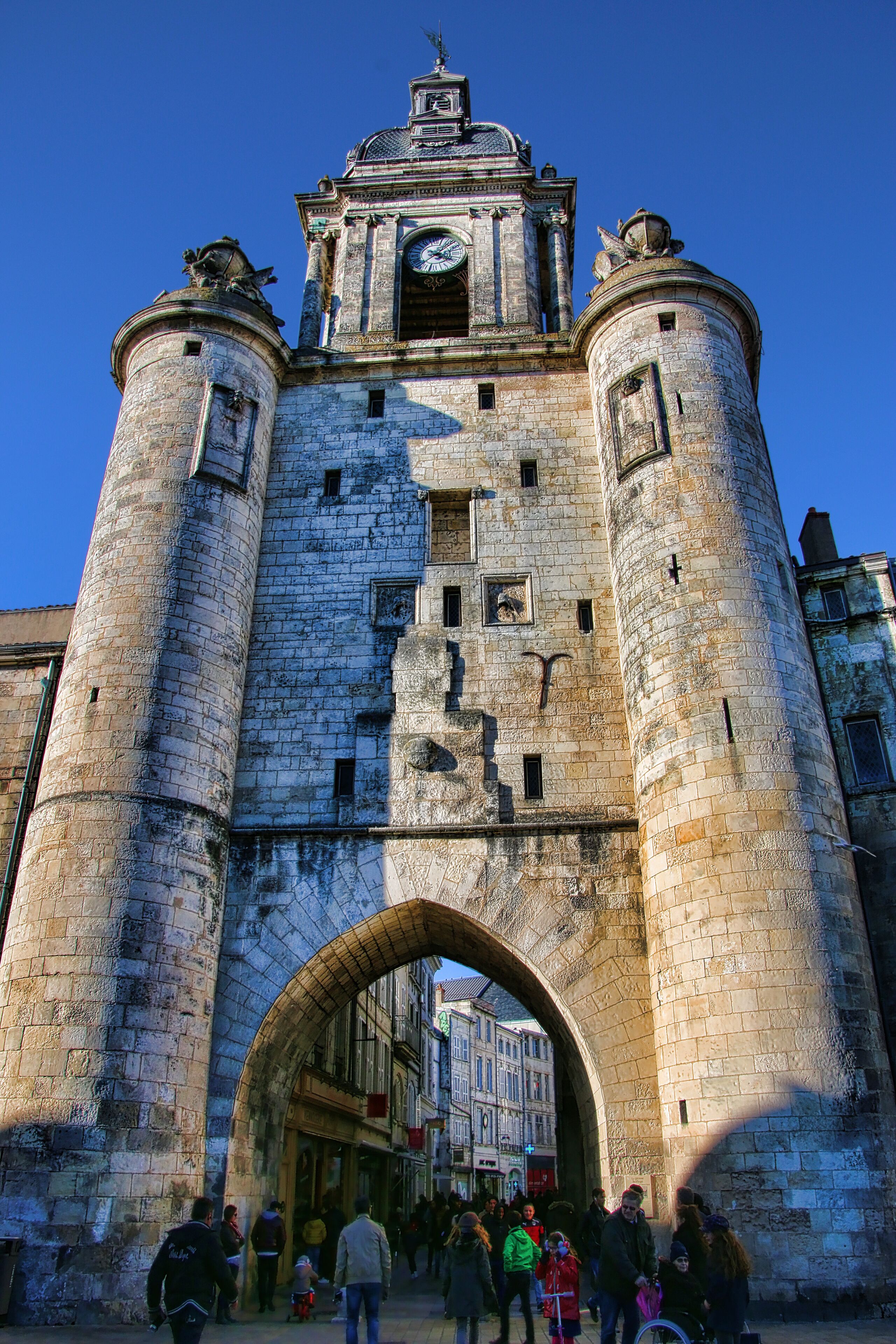 A historic stone tower with a clock and arched entrance.