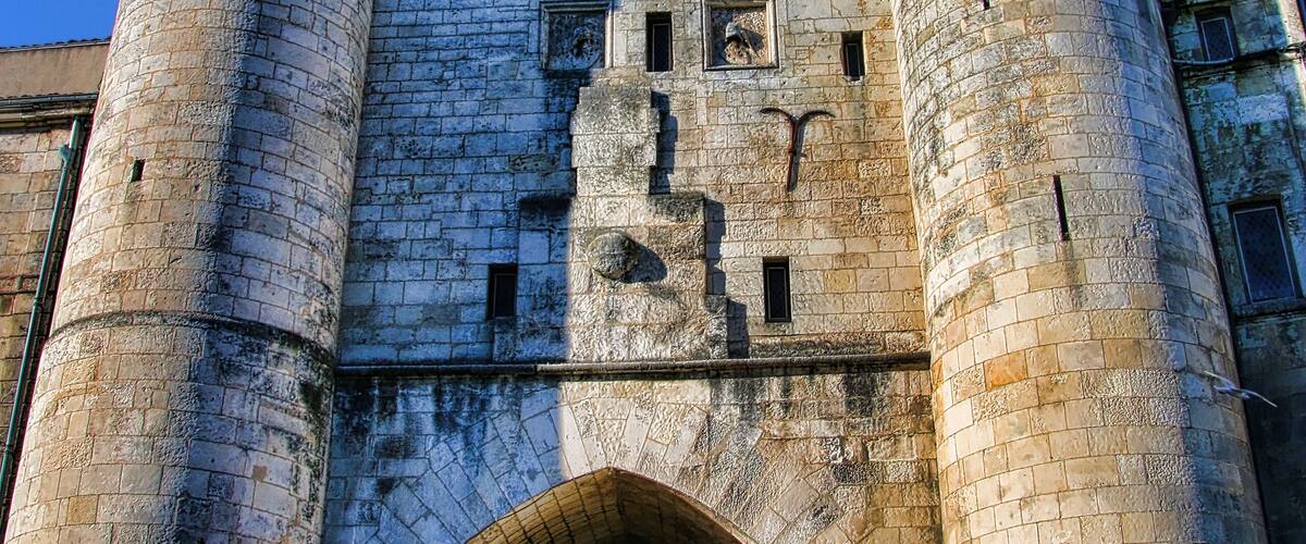 A historic stone tower with a clock and arched entrance.