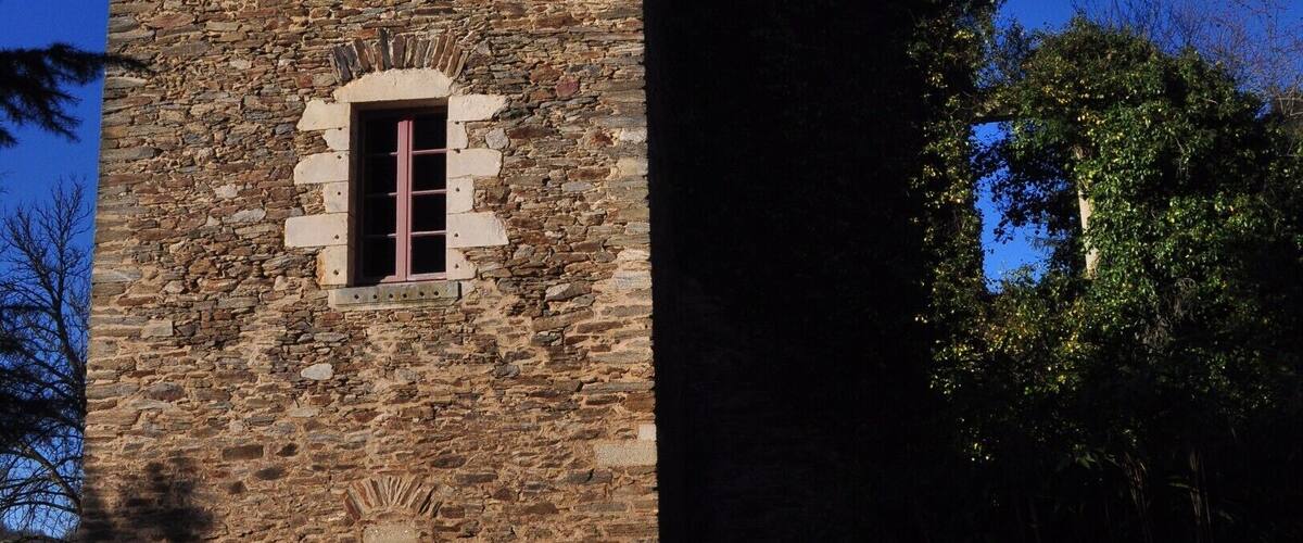 A stone tower with a pointed roof and a small window.