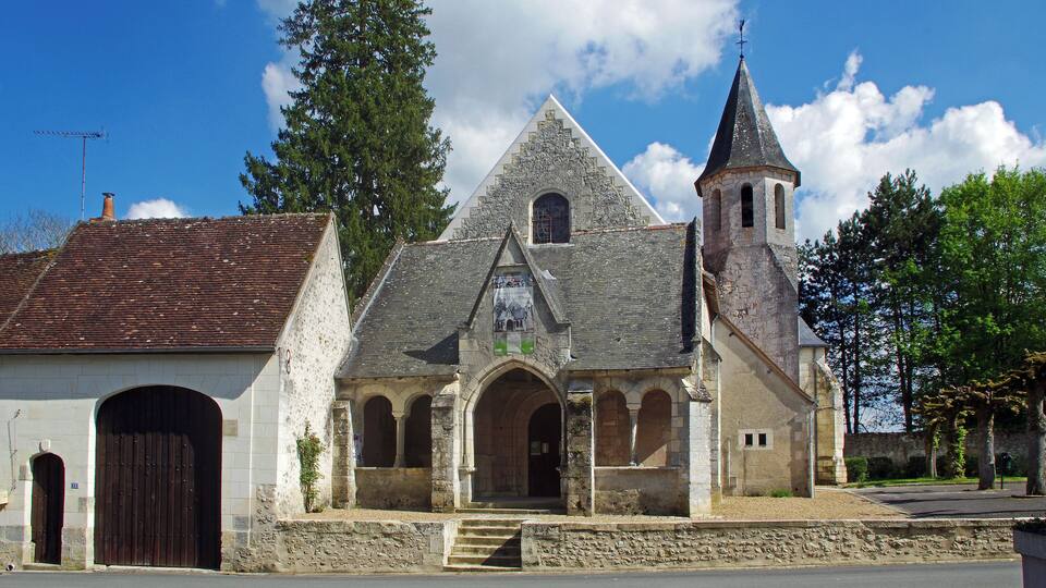 A historic church with a stone facade, a bell tower, and a large arched entrance.