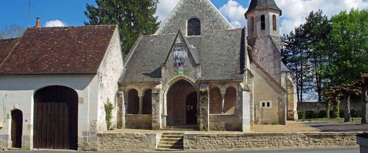 A historic church with a stone facade, a bell tower, and a large arched entrance.