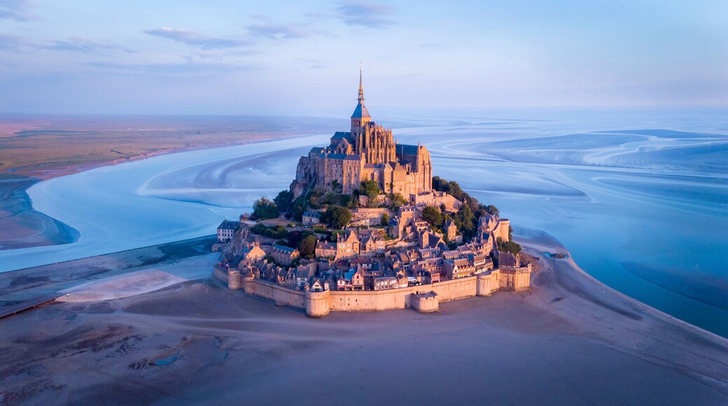 Aerial view of Mont Saint-Michel by river against sky during sunset