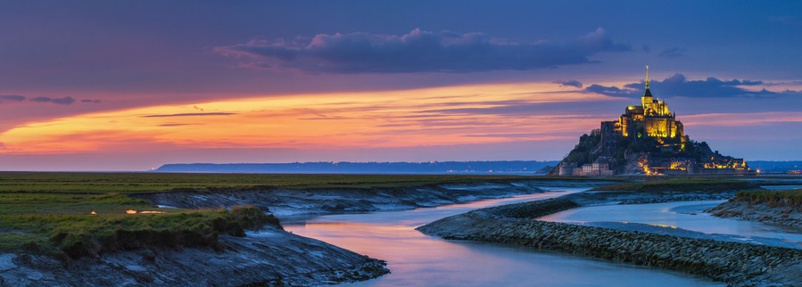 Panoramic view of famous Le Mont Saint-Michel tidal island at sunset, Normandy, northern France