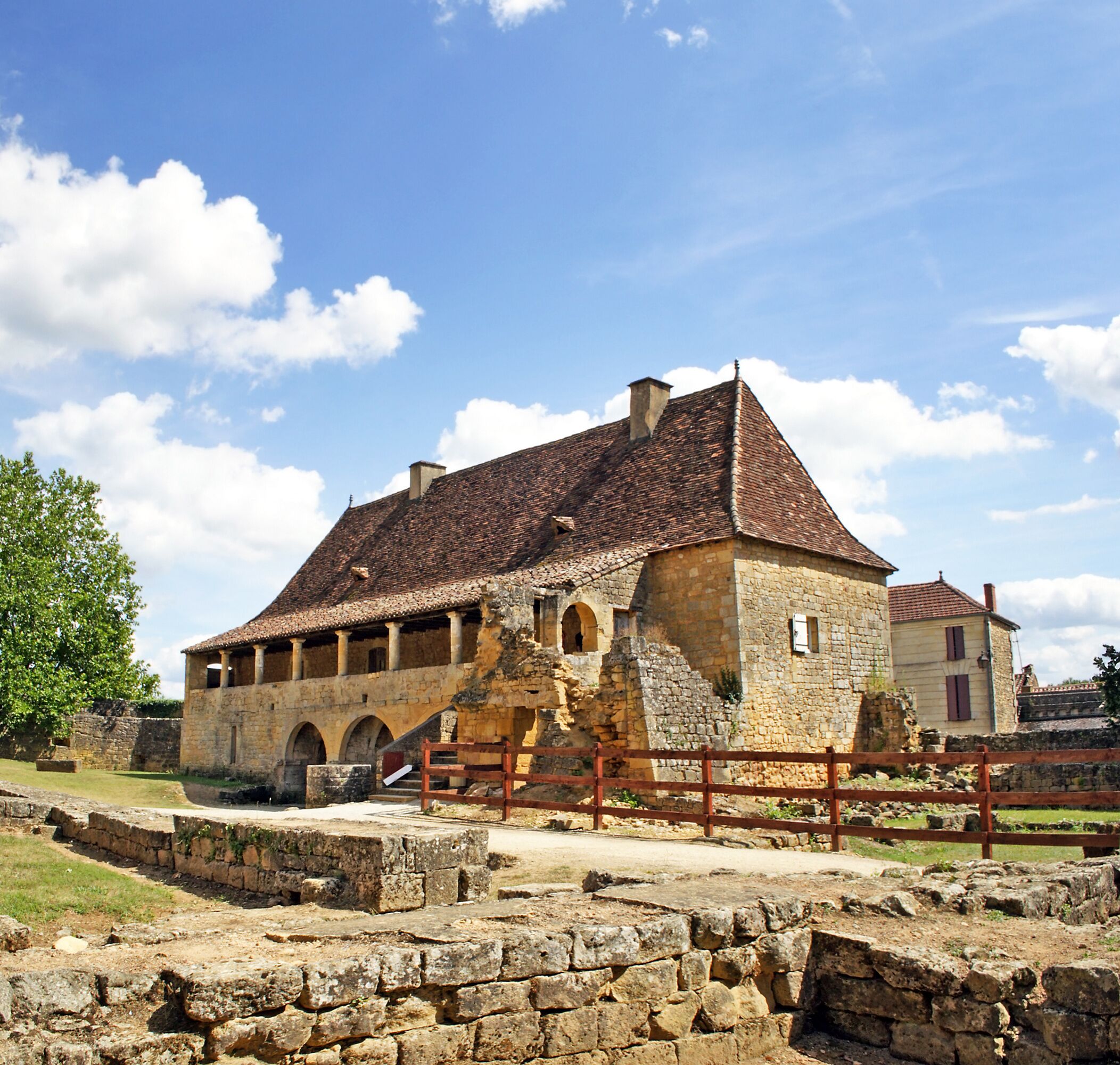 A historic stone building with a tiled roof and arched windows.