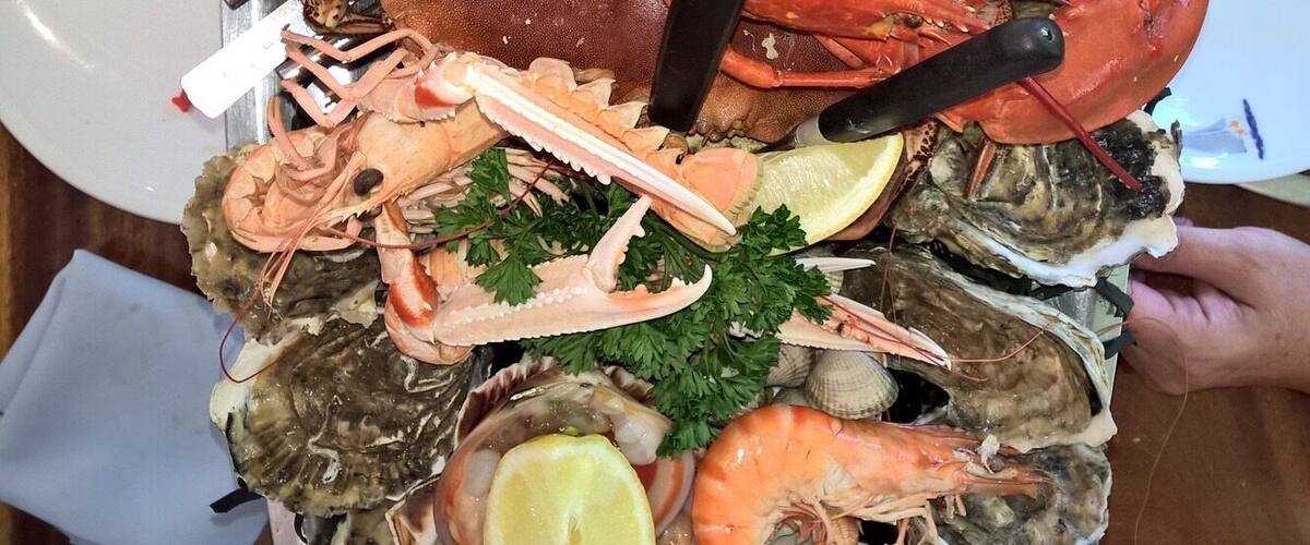 A seafood platter with various shellfish and a lemon wedge.