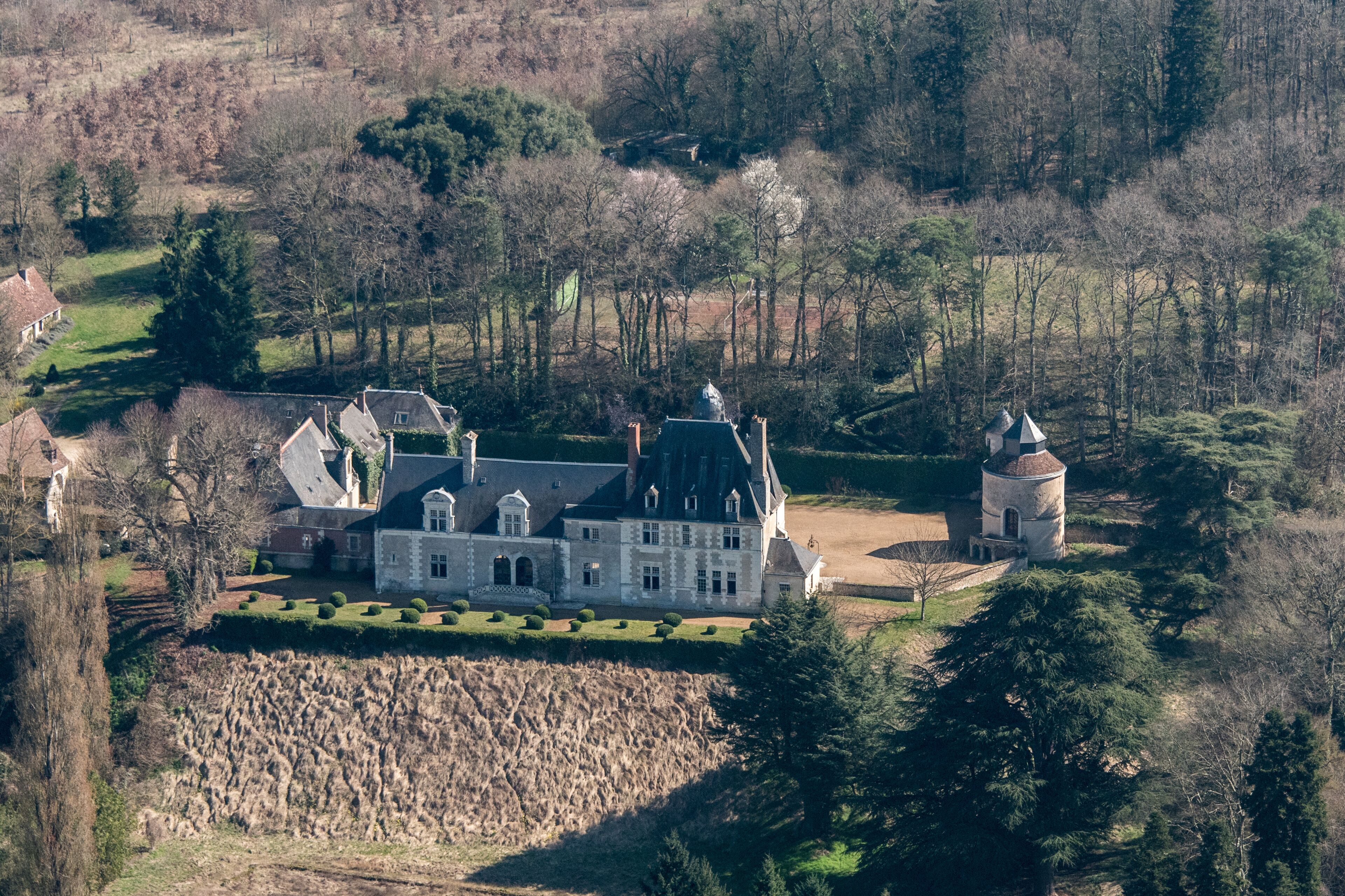 A large stately manor with multiple towers and a well-manicured garden.