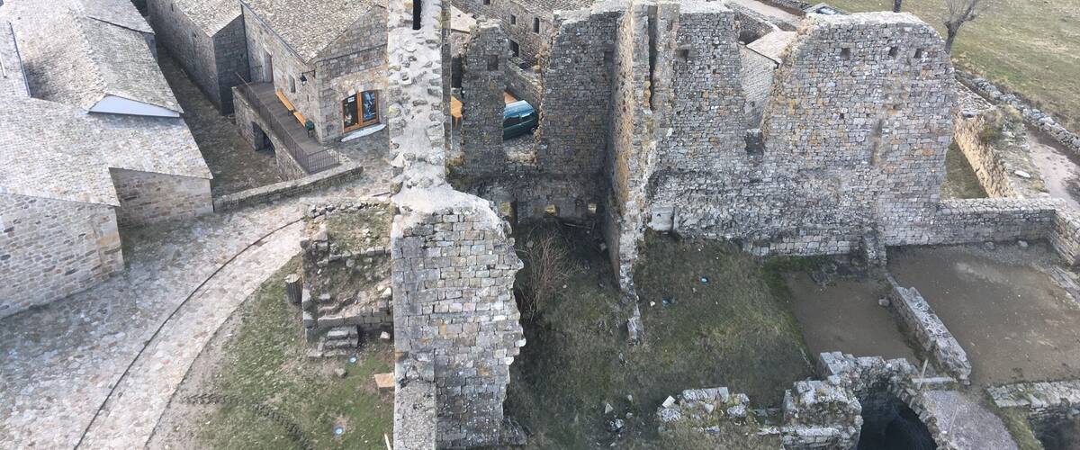 An aerial view of a historic stone village with ruins and traditional buildings.