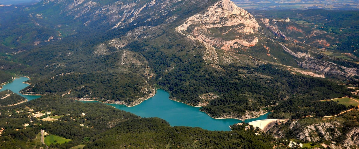 A mountainous landscape with a lake and a dam.