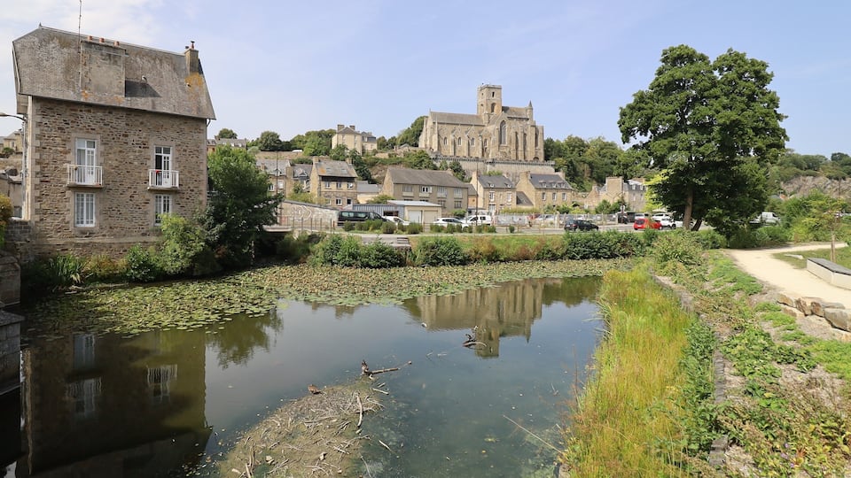 A historic town with a river, a prominent church, and stone buildings.