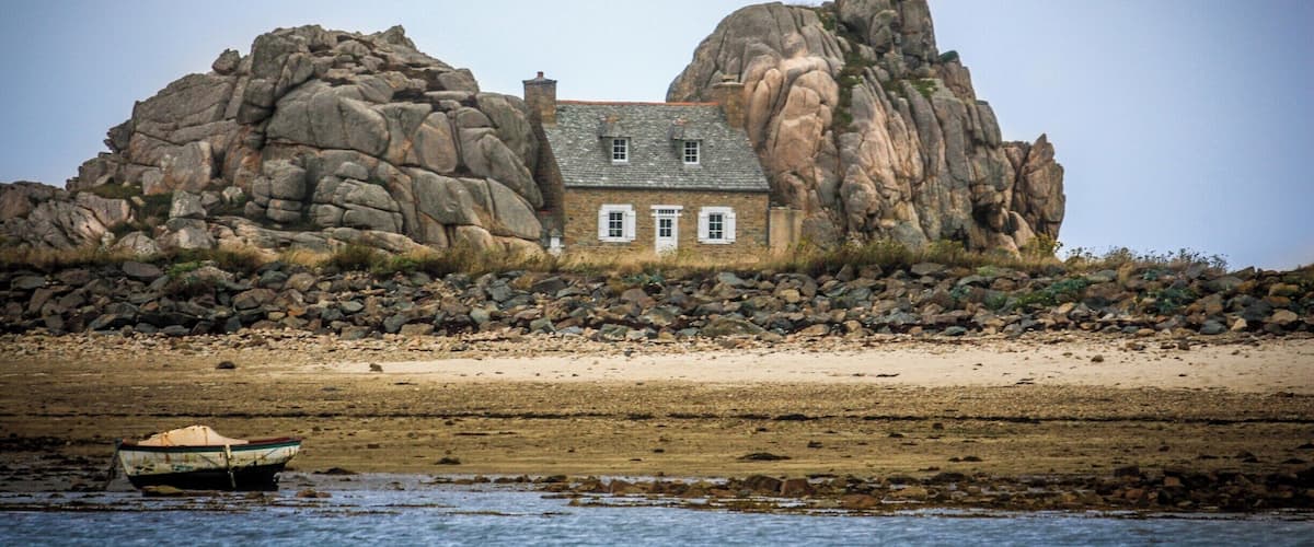 Small house built in between huge rocks on the Brittany coast near Plougrescant.