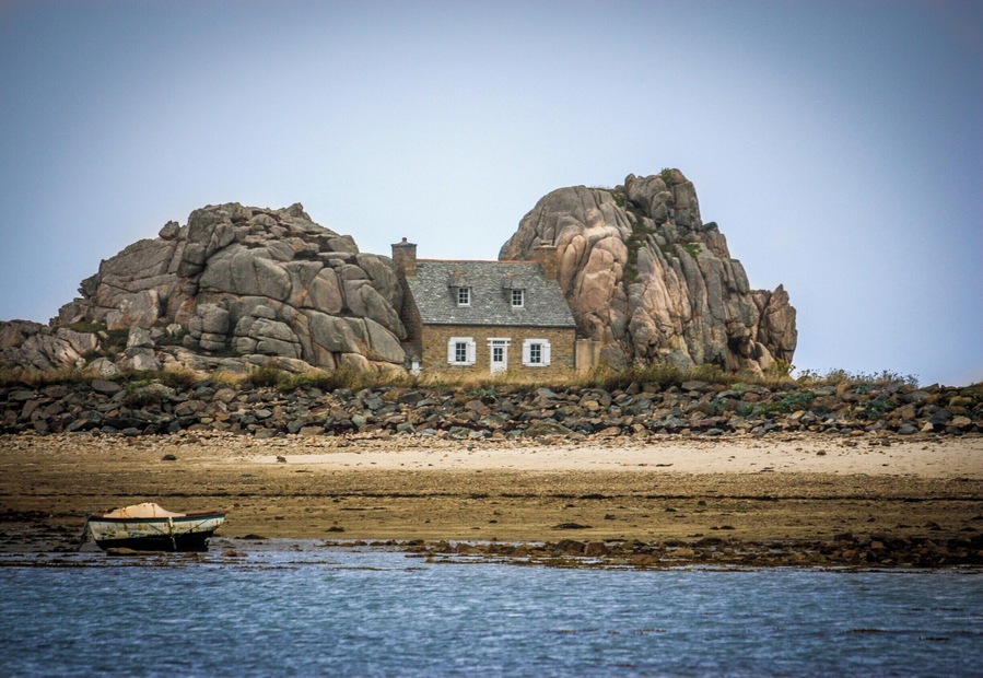 Small house built in between huge rocks on the Brittany coast near Plougrescant.