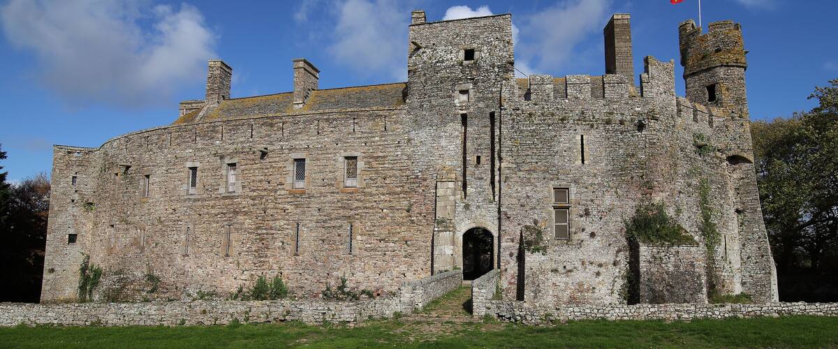 A historic stone castle with multiple towers and a flag.