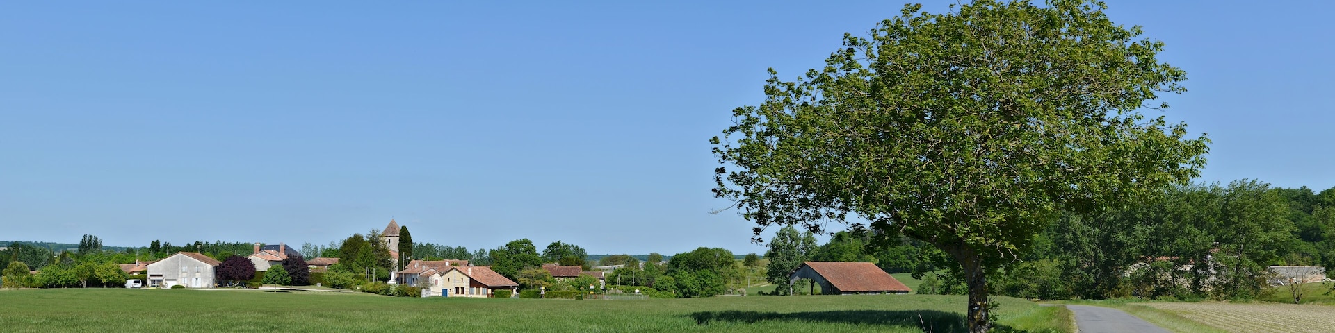 Road D 458 and west view of the village of Pillac, Charente, France.