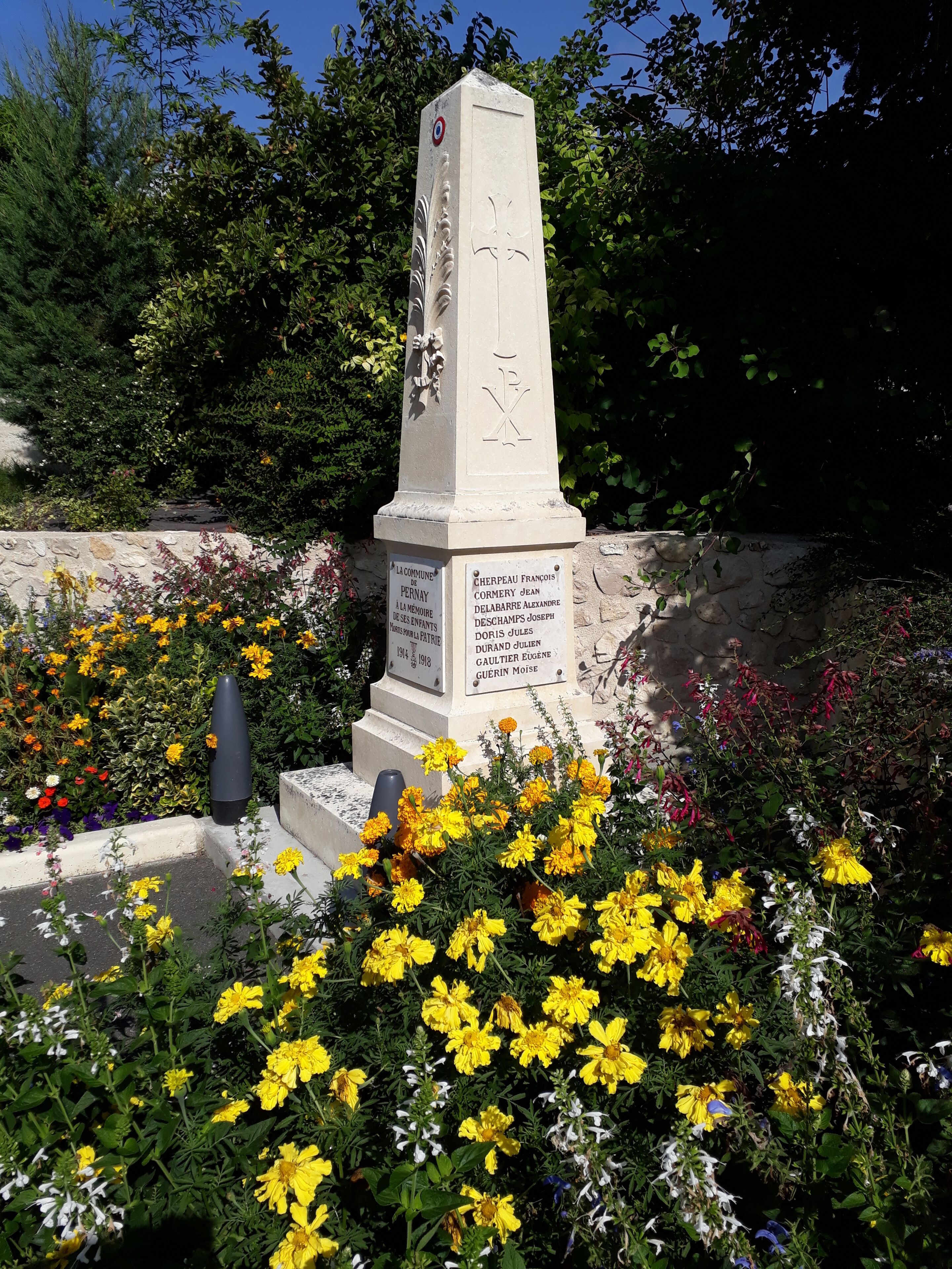 A memorial monument surrounded by colorful flowers.