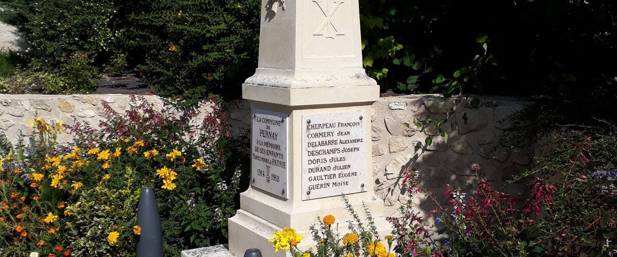 A memorial monument surrounded by colorful flowers.