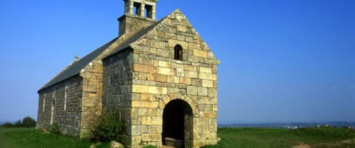 A small stone church with a bell tower and an arched entrance.