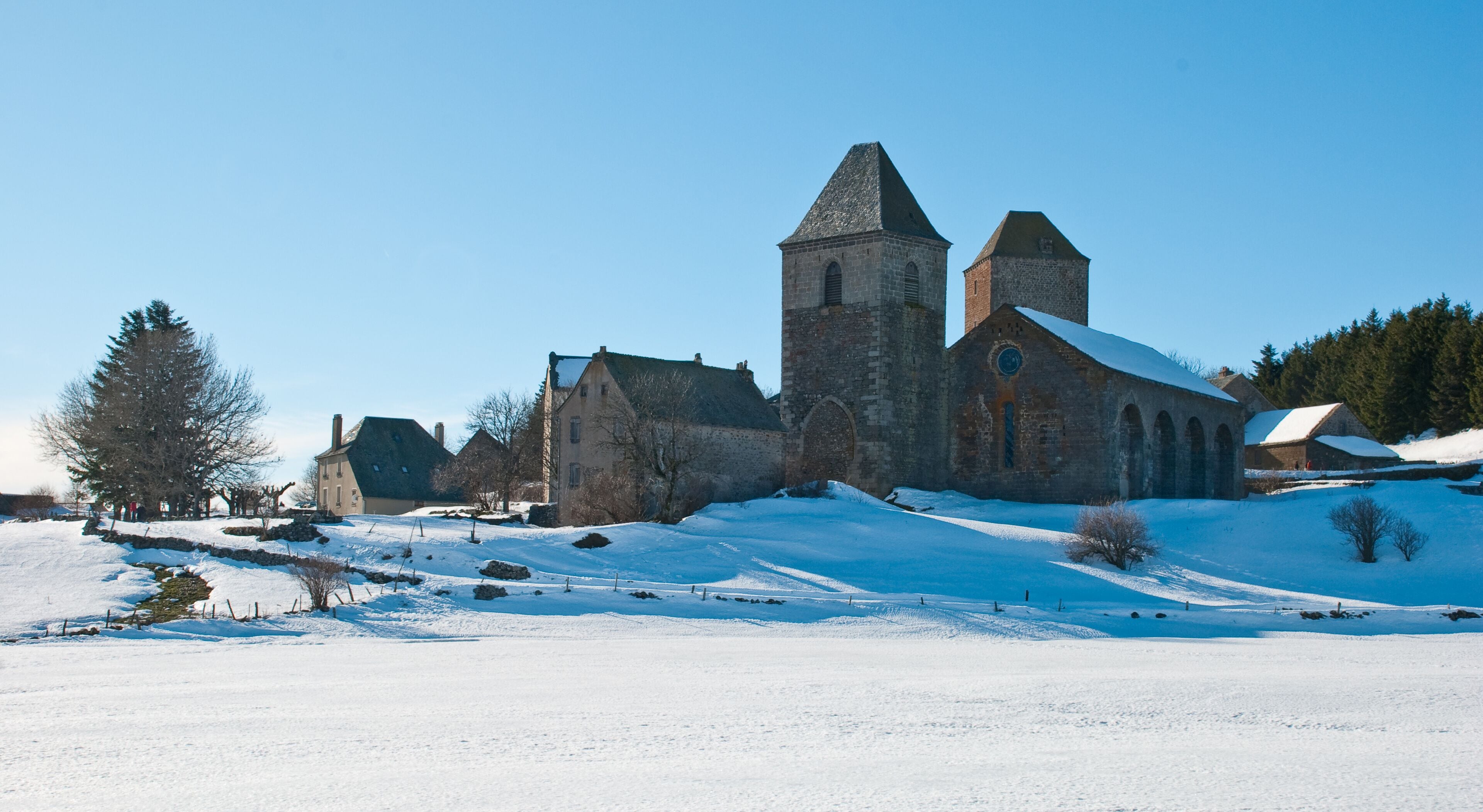 A historic church with a tall tower and snow-covered landscape.