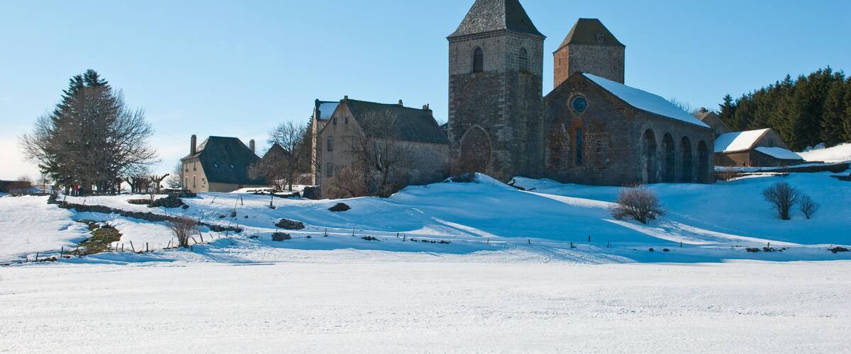 A historic church with a tall tower and snow-covered landscape.