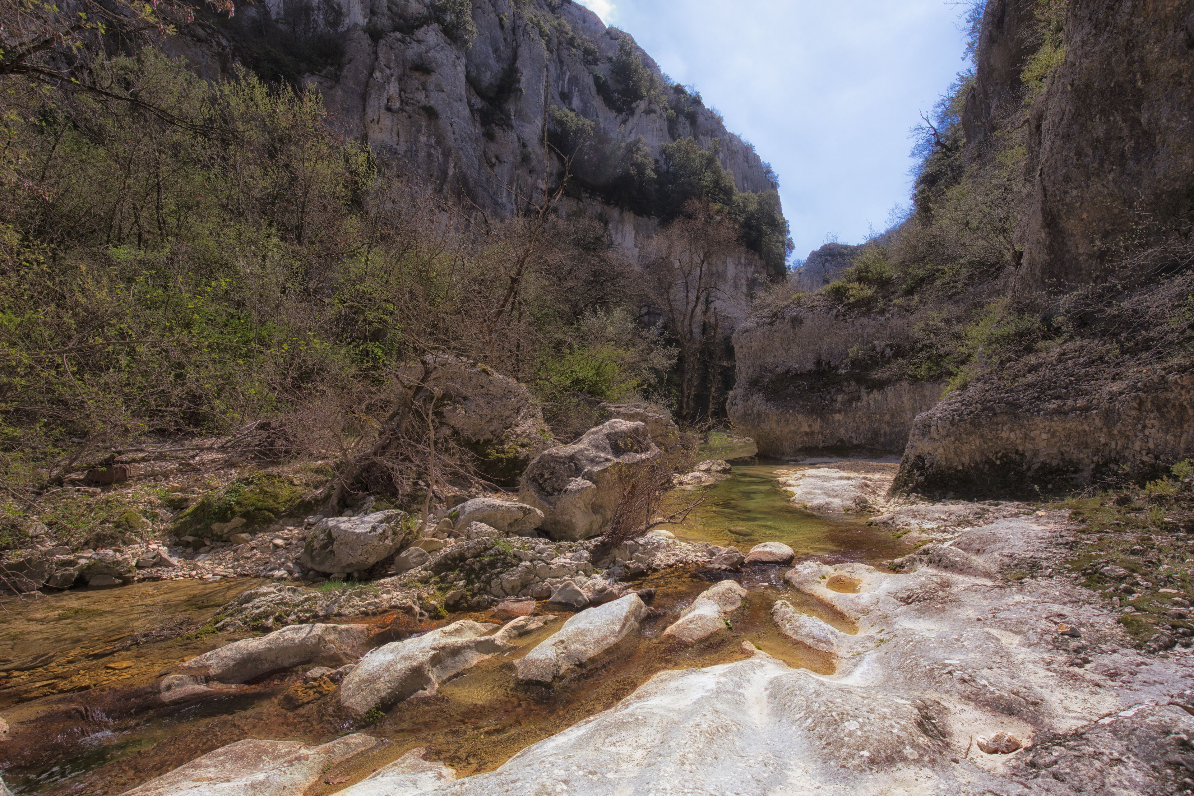 Een rivier die door een kloof stroomt, met rotsachtig terrein en schaarse begroeiing.