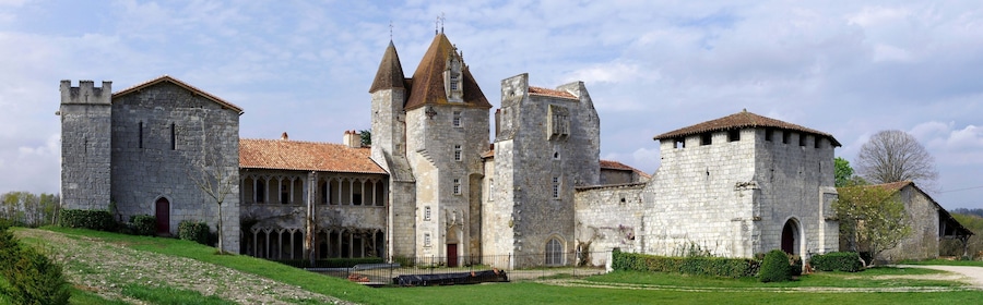 A historic stone castle with multiple towers and a red-tiled roof.