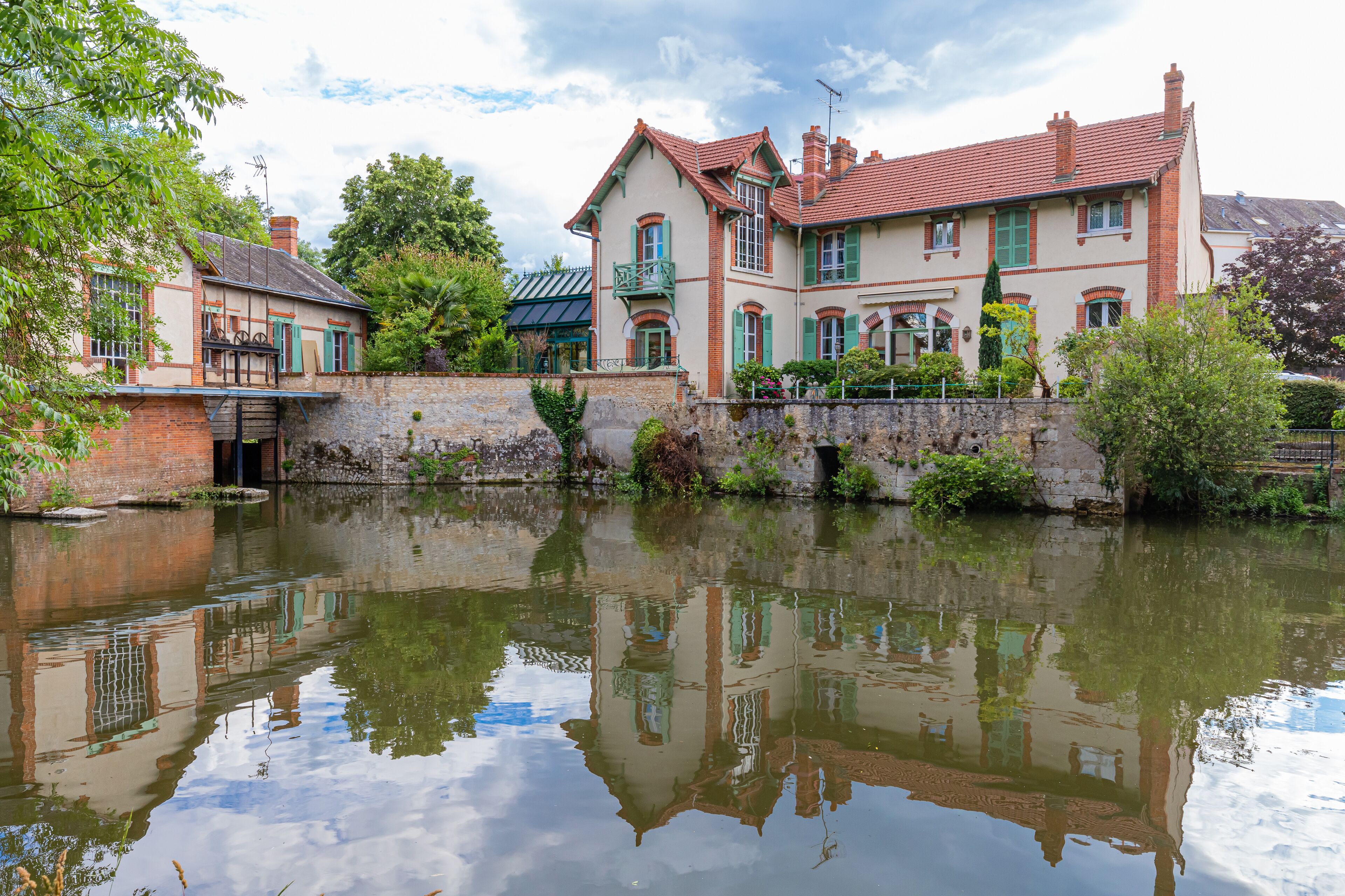 A canal with a row of historic houses reflecting in the water.