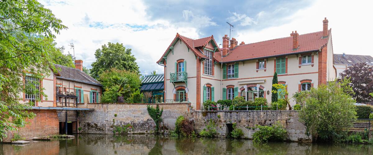 A canal with a row of historic houses reflecting in the water.