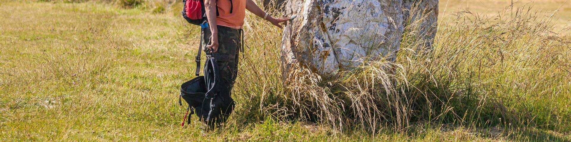young woman in a field of megalithic menhirs in Brittany near Camaret sur Mer, France
