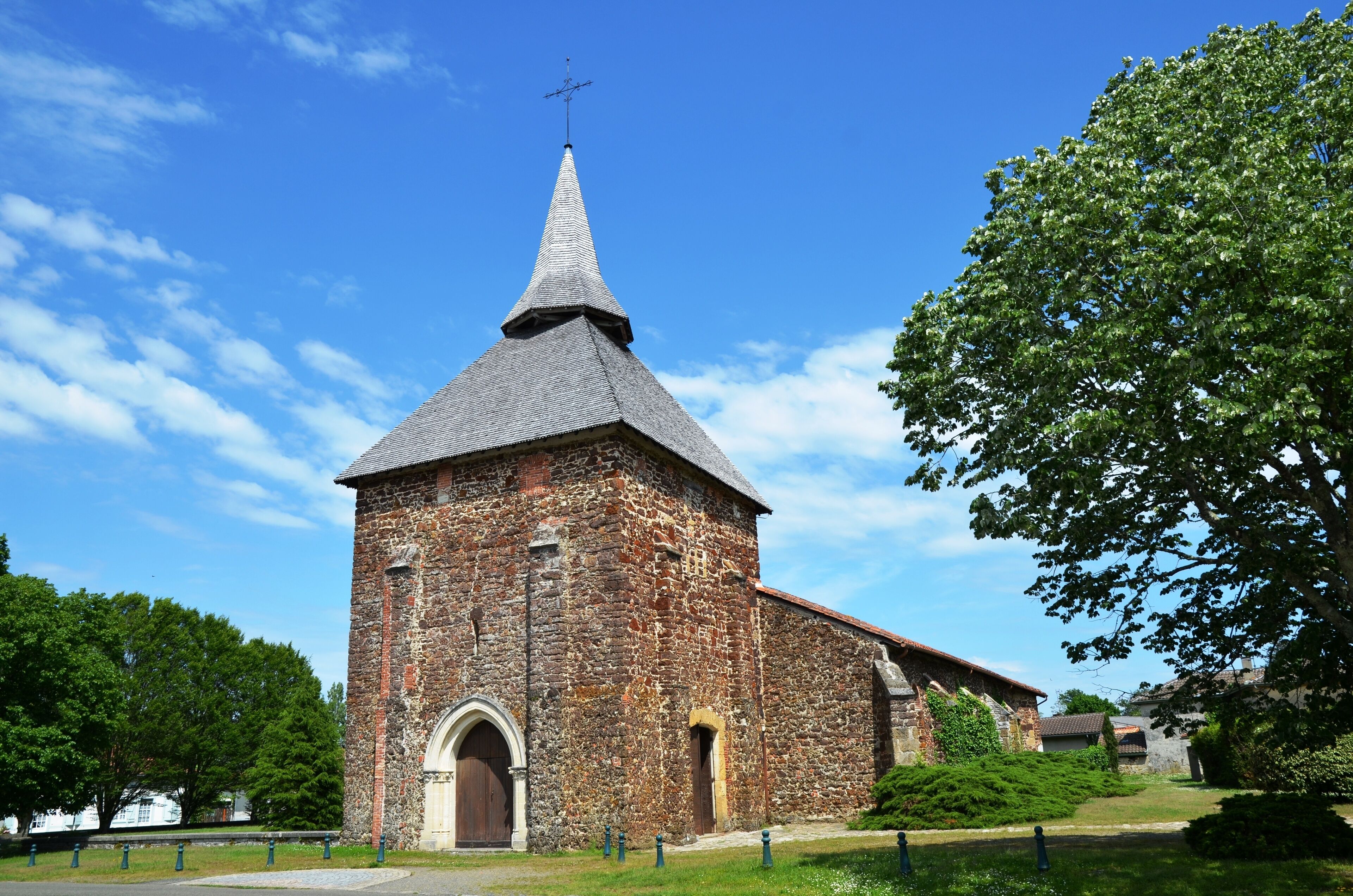 A historic stone church with a pointed steeple and arched entrance.