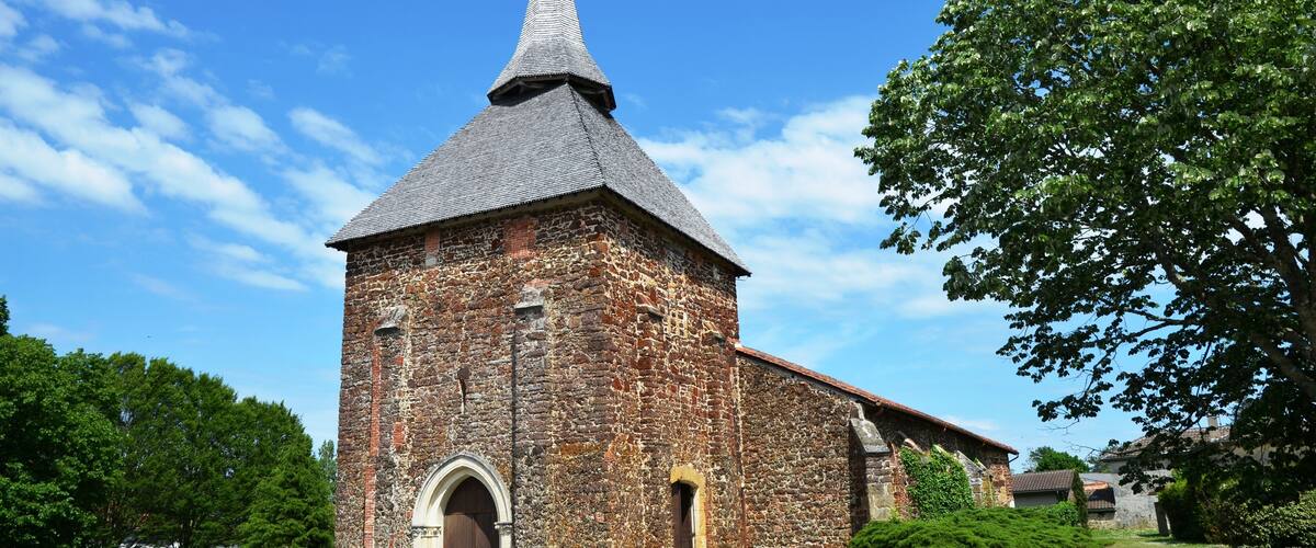 A historic stone church with a pointed steeple and arched entrance.