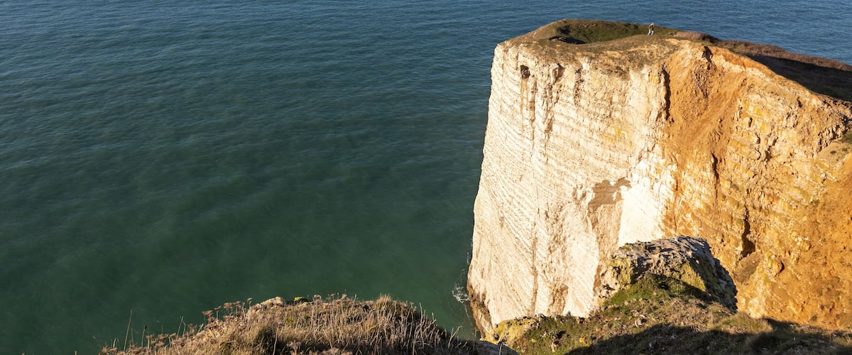 A coastal cliff with a clear view of the ocean.