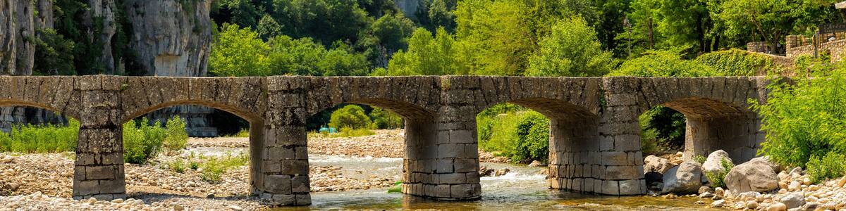 Large panoramic view of the old bridge over the Ardeche near Labeaume in France
