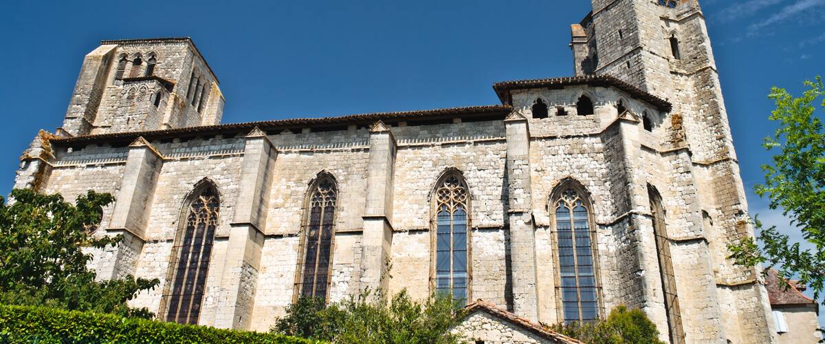 A historic stone church with tall bell towers and large arched windows.