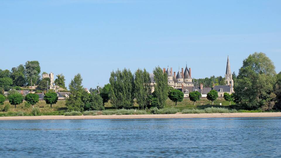 A river with a castle and church in the background.