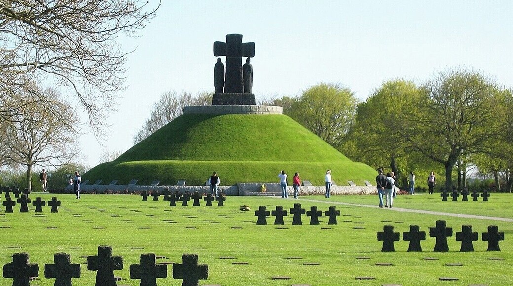 The remains of over 21,000 German solders killed during the first few months of the Allied invasion are interred here, many of them moved from other ad hoc burial sites across France. The entrance sign reads, in part: "With its melancholy rigour, it is a graveyard for soldiers not all of whom had chosen either the cause or the fight".