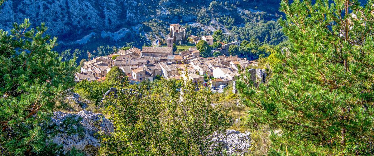 A mountainous village with historic buildings and a prominent tower.
