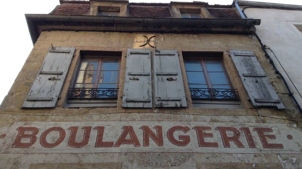A building with the sign "BOULANGERIE" and shuttered windows.