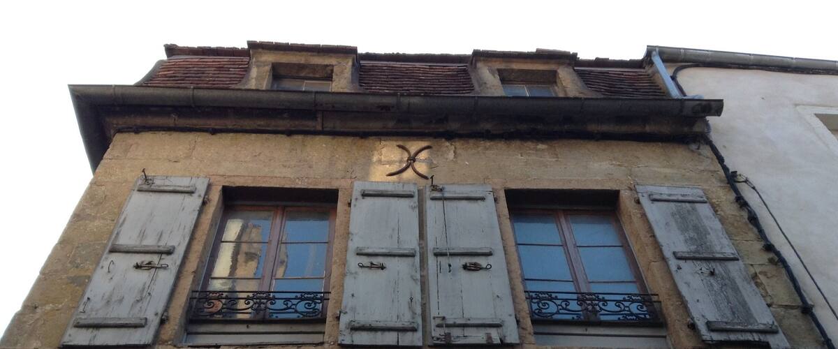 A building with the sign "BOULANGERIE" and shuttered windows.